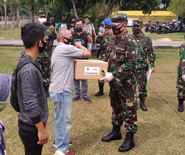 Komandan Lanud Roesmin Nurjadin Marsekal Pertama TNI Ronny Irianto Moningka membagikan bingkisan kepada perwakilan wartawan di halaman Rumah Sakit Angkatan Udara Dokter Sukirman, Sabtu (23/5/2020). Foto: Surya/Riau1.