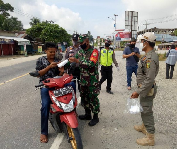 Babinsa Sungai Kijang Kopda Suprihadi meminta pengendara motor selalu gunakan masker, Minggu (24/5/2020). Foto: Istimewa.