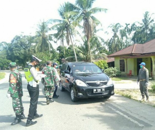 Anggota Koramil 11 Tambusai Kodim 0313 Kampar ikut memantau arus balik warga yang akan masuk ke Kabupaten Rohul, Rabu (27/5/2020). Foto: Istimewa.