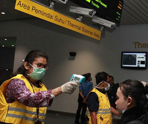 Petugas Kantor Kesehatan Pelabuhan (KKP) Kelas 1 Bandara Soetta melakukan pemeriksaan suhu tubuh penumpang pesawat yang tiba di Terminal 3 Bandara Soekarno Hatta, Tangerang, Banten. Foto: Antara.