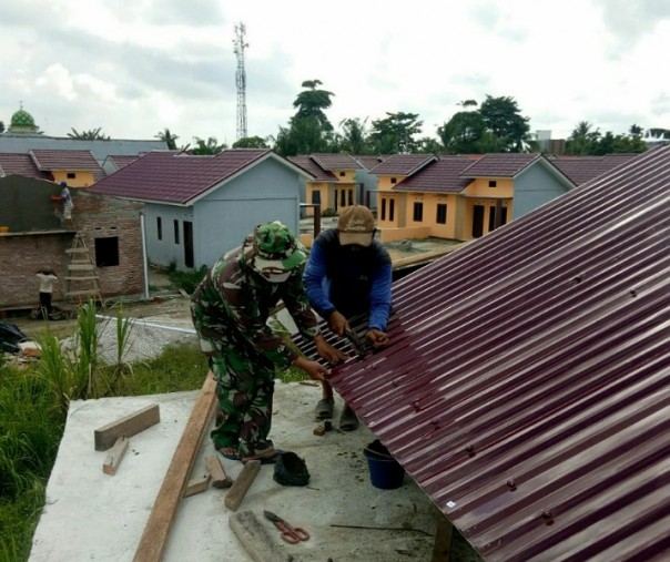 Babinsa Serma Sahuli Kerinci Timur Pelalawan membantu warga memasang atap musala, Kamis (4/6/2020). Foto: Istimewa.