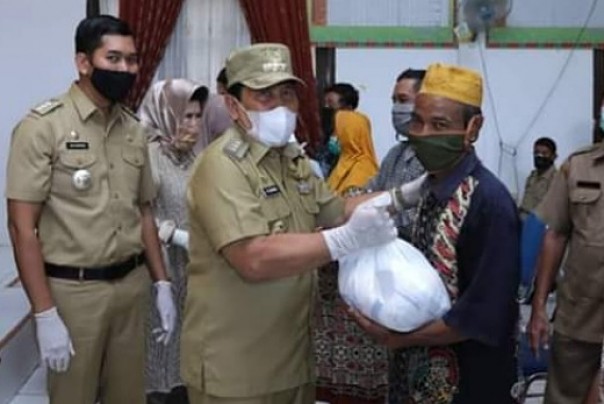 Bupati Rohul, Sukiman saat menyerahkan bantuan sembako secara simbolis kepada masyarakat Kecamatan Rambah Hilir