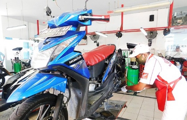 Teknisi AHASS gunakan masker dan sarung tangan saat melayani konsumen yang melakukan servis sepeda motor