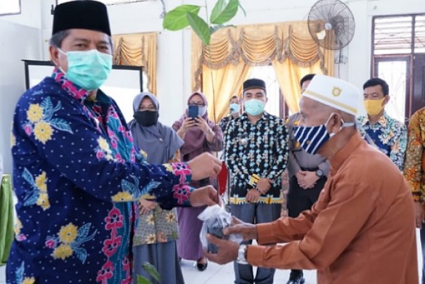 Bupati Siak, Alfedri menyerahkan secara simbolis bibit tanaman kepada masyarakat Kecamatan Lubuk Dalam