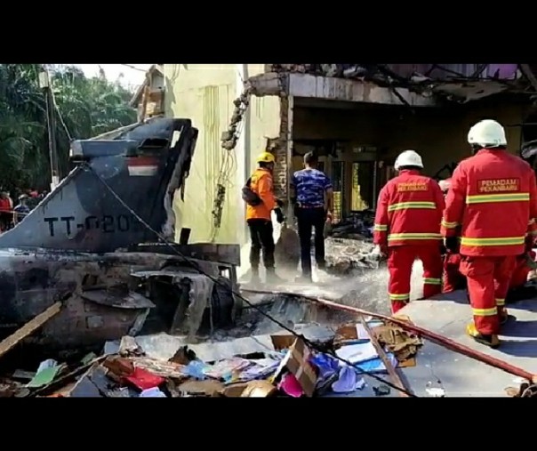 Petugas pemadam kebakaran saat memadamkan api dari pesawat tempur jatuh dan terbakar di Perumahan Kubang Sialang Indah, Dusun Sialang Indah, Desa Kubang Jaya, Kabupaten Kampar, Senin (15/6/2020). Foto: tangkapan gambar video.