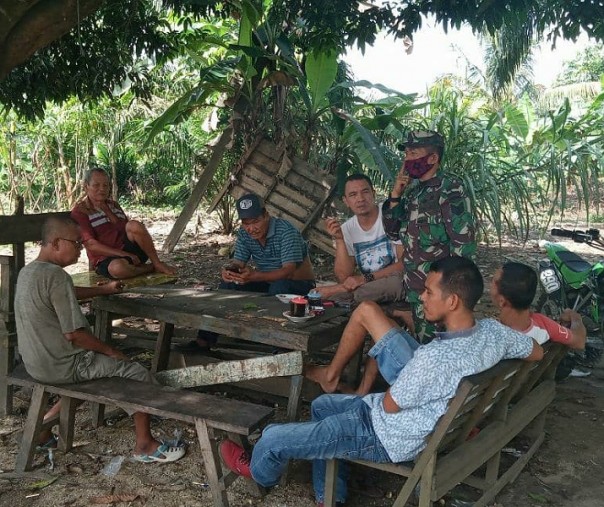 Babinsa Kelurahan Ujungbatu Serma Andri Mirzal saat melakukan komunikasi sosial kepada warga, Senin (15/6/2020). Foto: Istimewa.