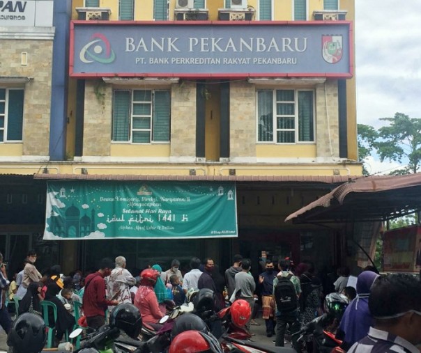 Warga penerima BLT dari Pemprov Riau mengantre di halaman Bank Pekanbaru, Jumat (19/6/2020). Foto: Riau1.