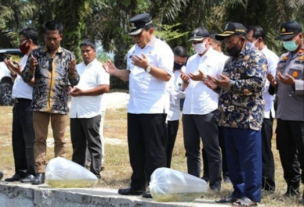 Bupati Rohul, Sukiman saat menabur benih ikan di Desa Rantau Sakti