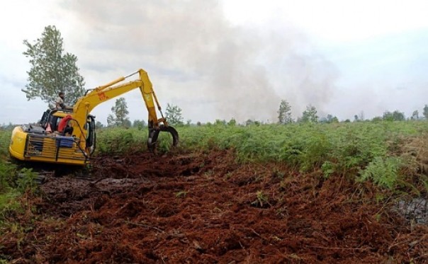 Excavator PT SRL sedang membuat sekat bakar dan embung air di sekitar kebakaran lahan di Desa Pekan Tua