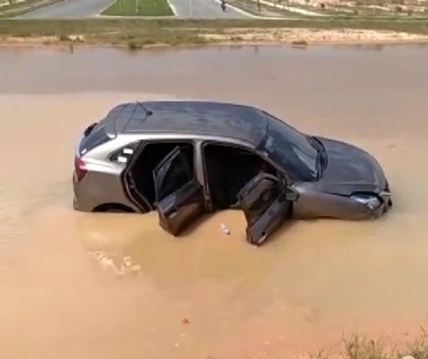 Sebuah mobil terjung ke kolam bundara Kompleks Perkantoran Tenayan Raya, Kamis (3/7/2020). Foto: Tangkapan layar.