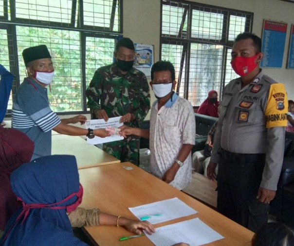 Babinsa Batu Langka Kecil Serka Nur Efendi saat penyaluran BLT DD tahap ketiga, Selasa (7/7/2020). Foto: Istimewa.