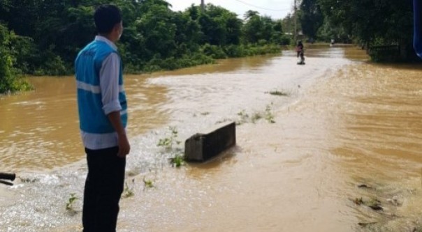 Petugas PLN saat meninjau kondisi jaringan listrik saat banjir melanda Kecamatan Kampar Kiri Hulu