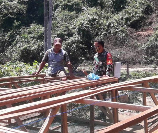 Babinsa Lubuk Bendahara Sertu Arnizam membantu warga membuat keramba ikan, Rabu (8/7/2020). Foto: Istimewa.