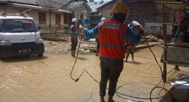 Petugas PLN saat meninjau kondisi jaringan listrik saat banjir melanda Kecamatan Kampar Kiri Hulu