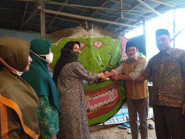 Rezita Meylani menerima layang-layang raksasa dari pengurus Karang Taruna Tunas Remaja Desa Kerubung Jaya, Kamis 9 Juli 2020