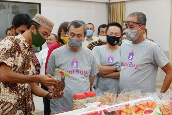 Kepala Disperindagkop-UMKM Riau, Asrizal mendampingi Gubri Syamsuar melihat hasil produk UMKM yang dijual di jualBuy.com (foto: dok/riau24group)
