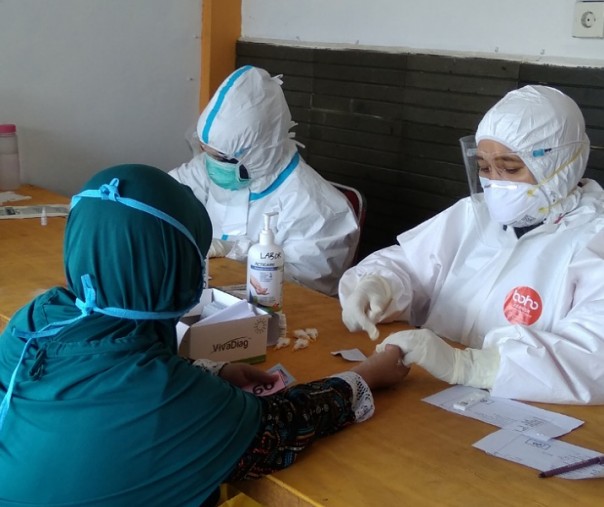 Petugas mengambil darah seorang warga saat proses rapid test di Halaman Rumah Tuan Kadi, Kecamatan Senapelan, Pekanbaru, beberapa waktu lalu. Foto: Surya/Riau1.