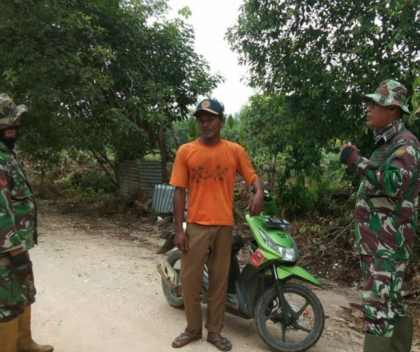 Dua Babinsa Koramil 07 Kampar menyampaikan imbauan bahaya karhutla ke warga Desa Rimbo Panjang, Senin (13/7/2020). Foto: Istimewa.