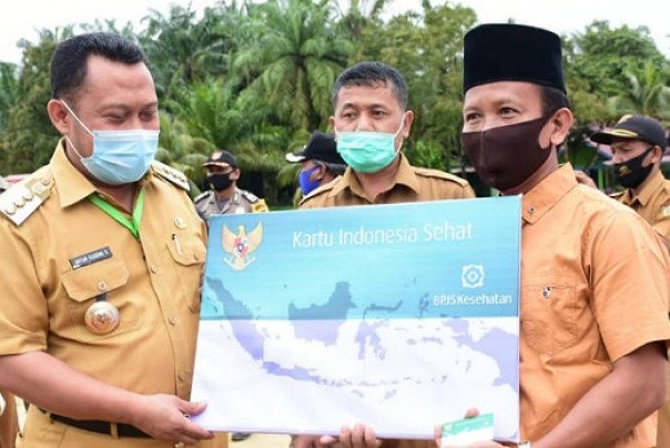 Bupati Kampar, Catur Sugeng Susanto menyerahkan secara simbolis program KIS