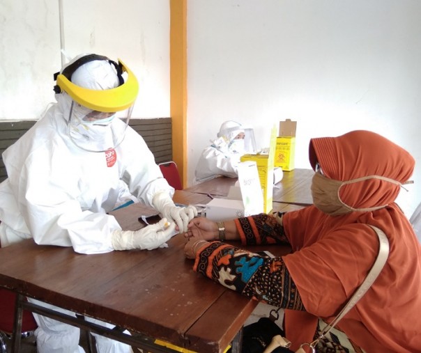 Petugas medis saat mengambil darah warga dalam pemeriksaan rapid test di Kawasan Rumah Tuan Kadi, Selasa (7/7/2020). Foto: Surya/Riau1.