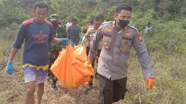 Kapolsek Tualang AKP Faizal Ramzani bersama warga setempat mengevakuasi jenazah korban