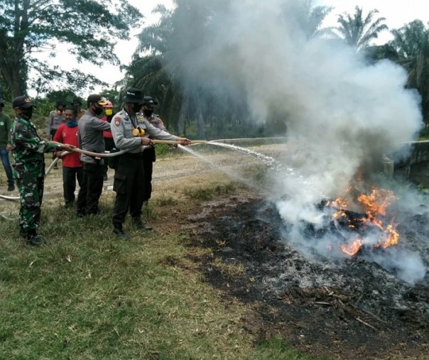 Babinsa Koramil 08 Tandun dan Bhabinkamtibmas Polsek Ujungbatu, tim Damkar PT SHI, dan MPA saat simulasi pemadaman karhutla, Rabu (22/7/2020). Foto: Istimewa.