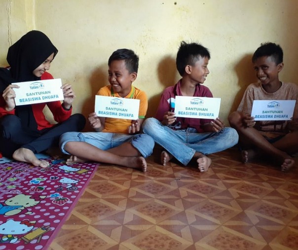 Angela Dwina (15), Dafa Afrian (12), Dafi Afrian (12), dan Muhammad Fahreza (10) saat menerima bantuan beasiswa dari Rumah Yatim Riau. Foto: Istimewa.