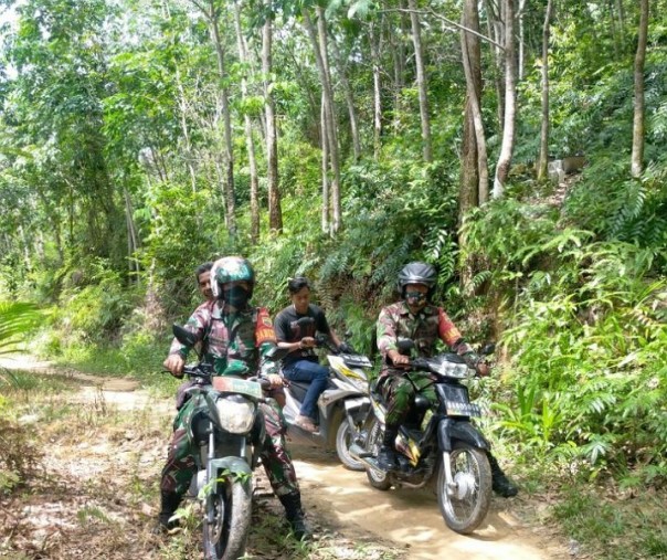 Babinsa Koramil 02 Rambah Samo Kodim 0313 Kampar saat patroli di kawasan hutan Desa Teluk Aur, Kabupaten Rohul, Kamis (30/7/2020). Foto: Istimewa.