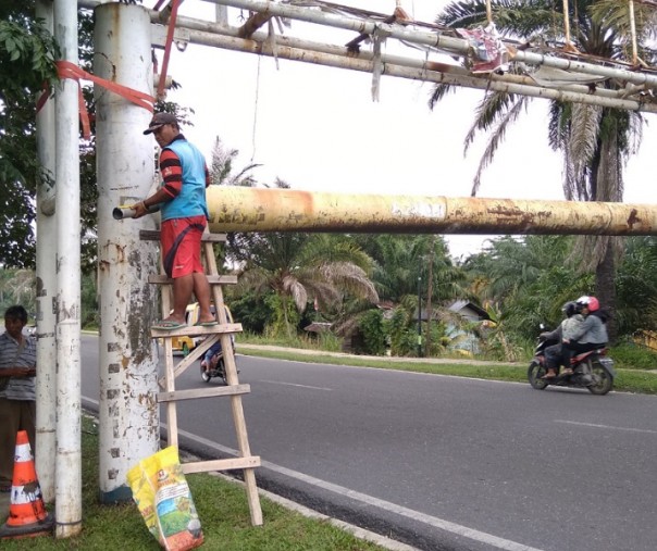 Pekerja dari PUPR Riau usai mengikat portal Jembatan Leighton yang miring dihantam mobil barang, Senin (3/8/2020). Foto: Surya/Riau1.