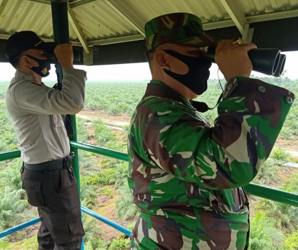 Petugas Polsek Pangkalan Lesung Pelalawan bersama anggota TNI AD mengecek kondisi perkebunan PT Musim Mas, Jumat (7/8/2020). Foto: Istimewa.