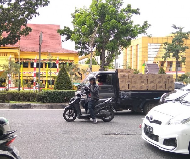 Seorang pengendara motor berhenti di tengah jalam sembari memasang masker di Jalan Jenderal Sudirman, Selasa (11/8/2020). Foto: Surya/Riau1.