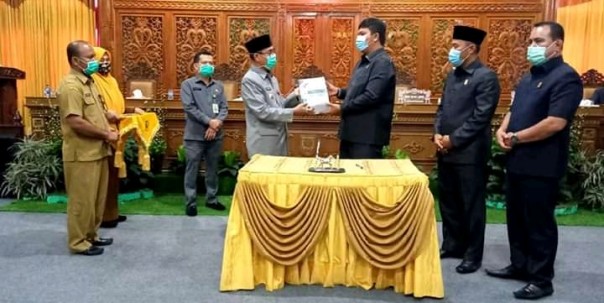 Ketua DPRD Kuansing Andi Putra saat menyerahkan Ranperda LPJ Tahun Anggaran 2019 kepada Bupati Drs H Mursini, M.Si setelah disetujui DPRD Kuansing/R24