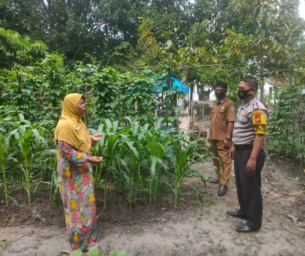 Kanit Binmas Polsek Ukui Aipda Dede Ismanto berbincang dengan seorang petani di Desa Tri Mulya Jaya, Pelalawan, Rabu (12/8/2020). Foto: Istimewa.