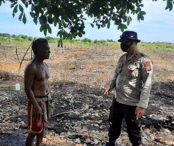 Kapolsek Kuala Kampar Iptu Hanova Siagian berbincang dengan warga saat mendata bekas lahan terbakar, Kamis (13/8/2020). Foto: Istimewa.