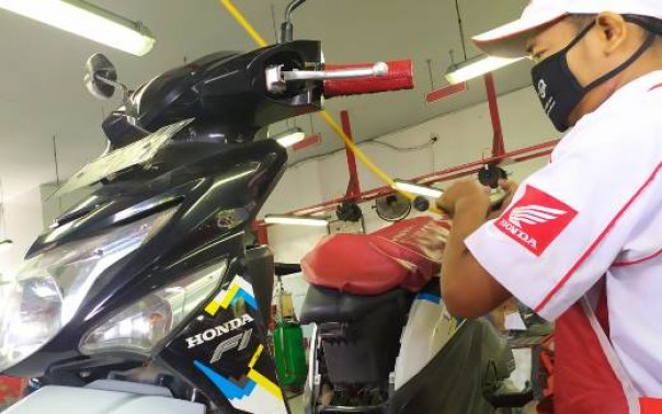Petugas mekanik AHASS sedang melakukan service perawatan sepeda motor Honda