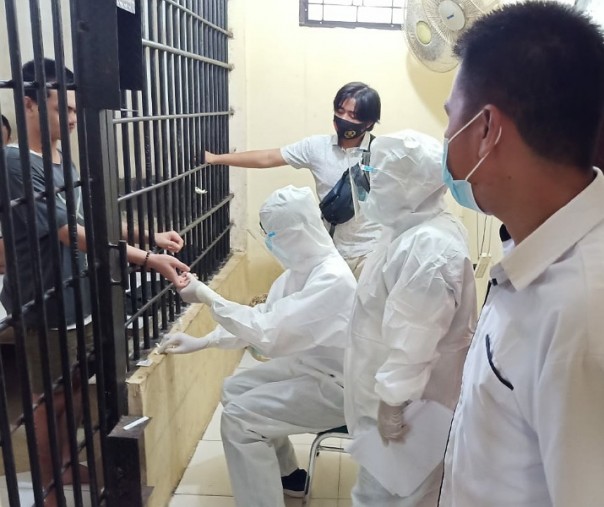 Tahanan Polsek Pangkalan Lesung menjalani proses rapid test dari balik ruang tahanan, Kamis (17/9/2020). Foto: Istimewa.