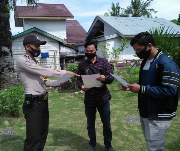 Personel Polsek Bunut saat menyebarkan Maklumat Kapolda Riau soal karhutla ke warga Desa Angkasa, Jumat (18/9/2020). Foto: Istimewa.
