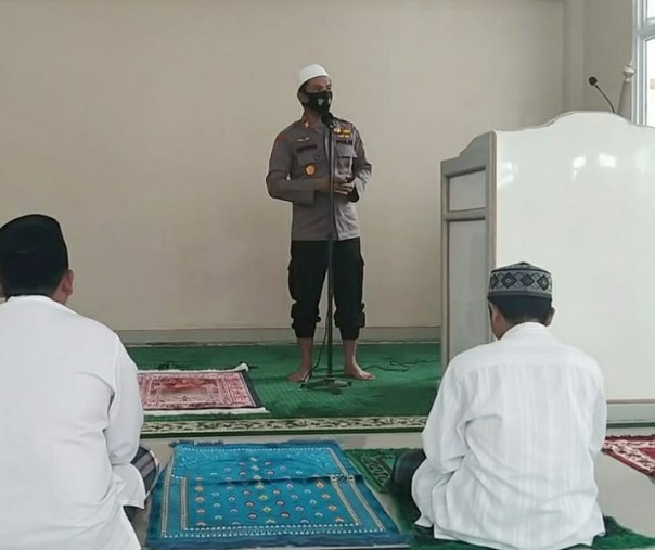 Kapolsek Ukui AKP Rifendi mensosialisasikan penggunaan masker kepada para jemaah sebelum khutbah Jumat di Masjid Jami' Al Muslimin, Jumat (18/9/2020). Foto: Istimewa.