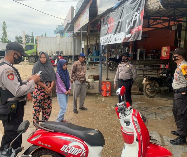 Personel Polsek Pangkalan Lesung menegur dua warga yang tak mengenakan masker di pusat perbelanjaan, Sabtu (19/9/2020). Foto: Istimewa.
