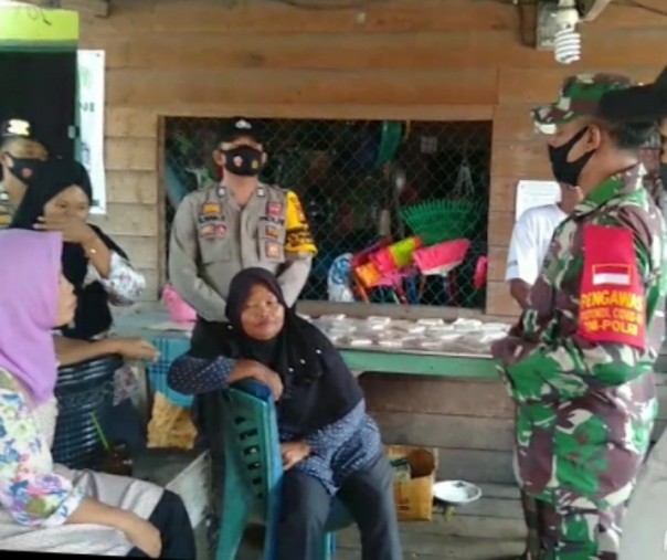 Personel Polsek Kuala Kampar bersama TNI menegur warga yang tak mengenakan masker di Pelabuhan Penyalai, Kelurahan Teluk Dalam, Sabtu (19/9/2020). Foto: Istimewa.