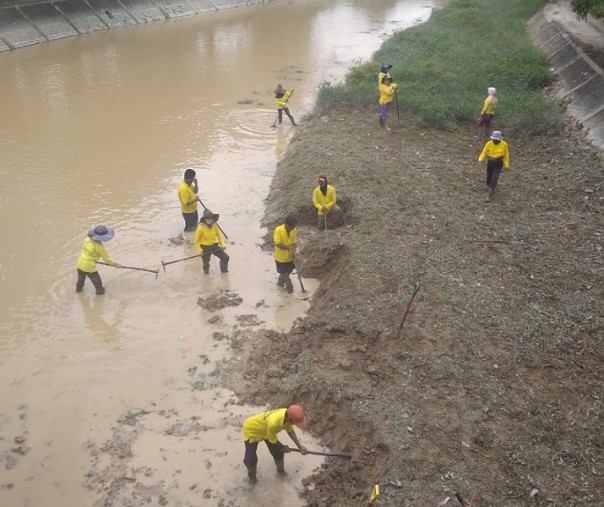 Para pekerja Dinas PUPR Pekanbaru menggali endapan tanah di bawah Jembatan Sail, Jalan Imam Munandar. Foto: Surya/Riau1.