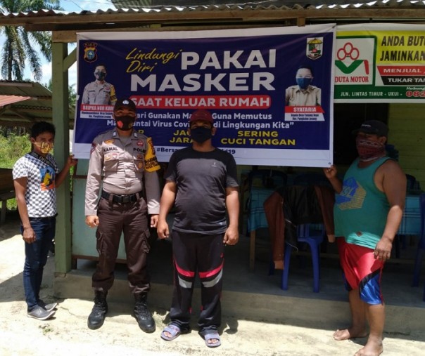 Spanduk protokol kesehatan dipasang di salah satu warung warga oleh personel Polsek Pangkalan Lesung, Senin (28/9/2020). Foto: Istimewa. 