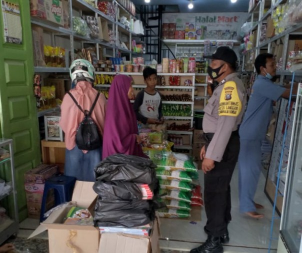 Personel Polsek Langgam saat menegur warga yang tak mengenakan masker di Desa Segati, Rabu (30/9/2020). Foto: Istimewa.