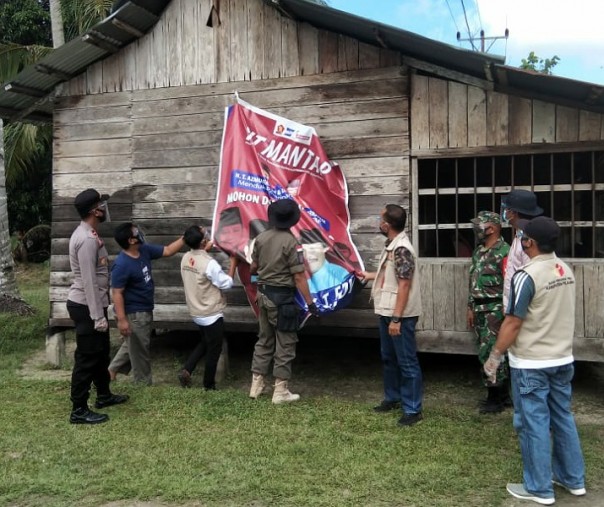 Kapolsek Teluk Meranti Ipda Dymas Bagus Bimantara mengawal petugas Panitia Pengawas Kecamatan (Panwascam) dalam penertiban alat peraga kampanye (APK) Pilkada Pelalawan, Rabu (30/9/2020). Foto: Istimewa.