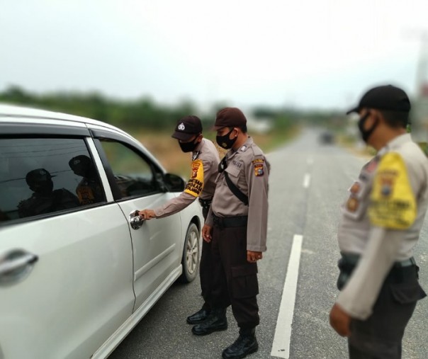 Personel Polsek Bunut melaksanakan kegiatan pemeriksaan kendaraan dan orang yang akan menuju Pekanbaru, Jumat (9/10/2020). Foto: Istimewa.