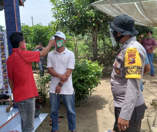 Personel Polsek Pangkalan Lesung mengawasi penerapan protokol kesehatan di lokasi kampanye tatap muka salah seorang pasangan calon bupati Pelalawan, Kamis (15/10/2020). Foto: Istimewa.