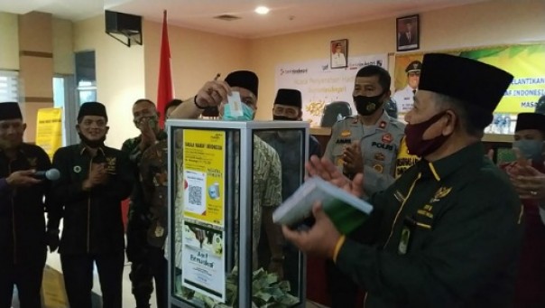 Bupati Inhu H Yopi Arianto SE (tengah) didampingi Kepala Cabang Bank Riau Kepri (BRK) Airmolek, Muhammad Ali Fahmi (kanan) dan Ketua BWI Riau, Masrul Kasmy (dua kiri) serta Ketua BWI Inhu, Addul Karim (kiri) memasukan hadiah kedalam kotak wakaf.