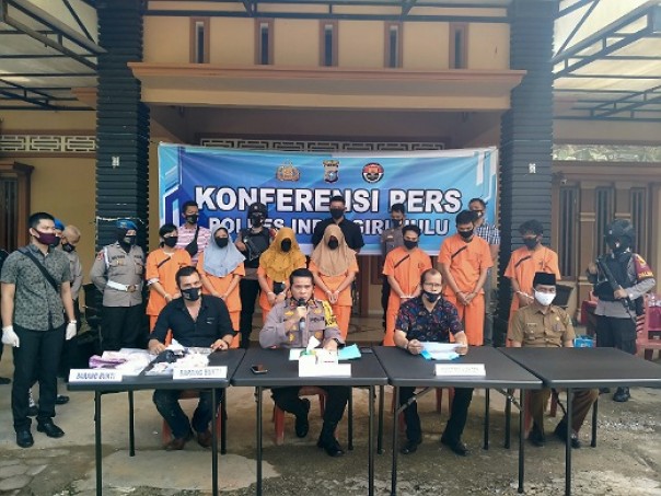 Ratu Sabu Inhu, Mak Gadih (tiga kiri) bersama 6 tersangka lainnya, menggunakan baju tahanan, di hadapkan ke awak media, dalam konferensi pers yang di pimpin Kapolres Inhu AKBP Eftizal (depan tengah) di TKP, di kediaman Mak Gadih, Juli 2020 lalu