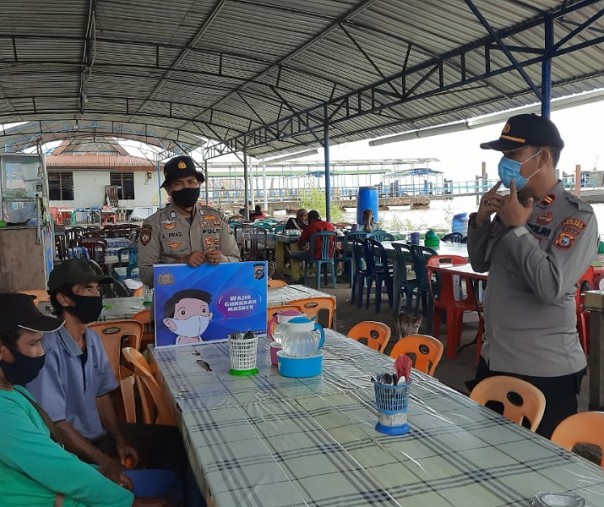 Kapolsek Kuala Kampar Iptu Hanova Siagian saat sosialisasi prokes ke warga Teluk Dalam, Senin (19/10/2020). Foto: Istimewa.