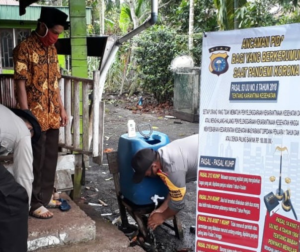 Polsek Kuala Kampar memeriksa lokasi kampanye salah satu paslon cakada Pelalawan di Kampung Teluk Air, Kelurahan Teluk Dalam, Kamis (22/10/2020). Foto: Istimewa.